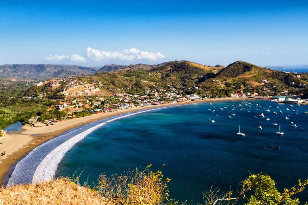 A look of San Juan Del Sur. The beach surrounded by volcanoes and filled with boats.